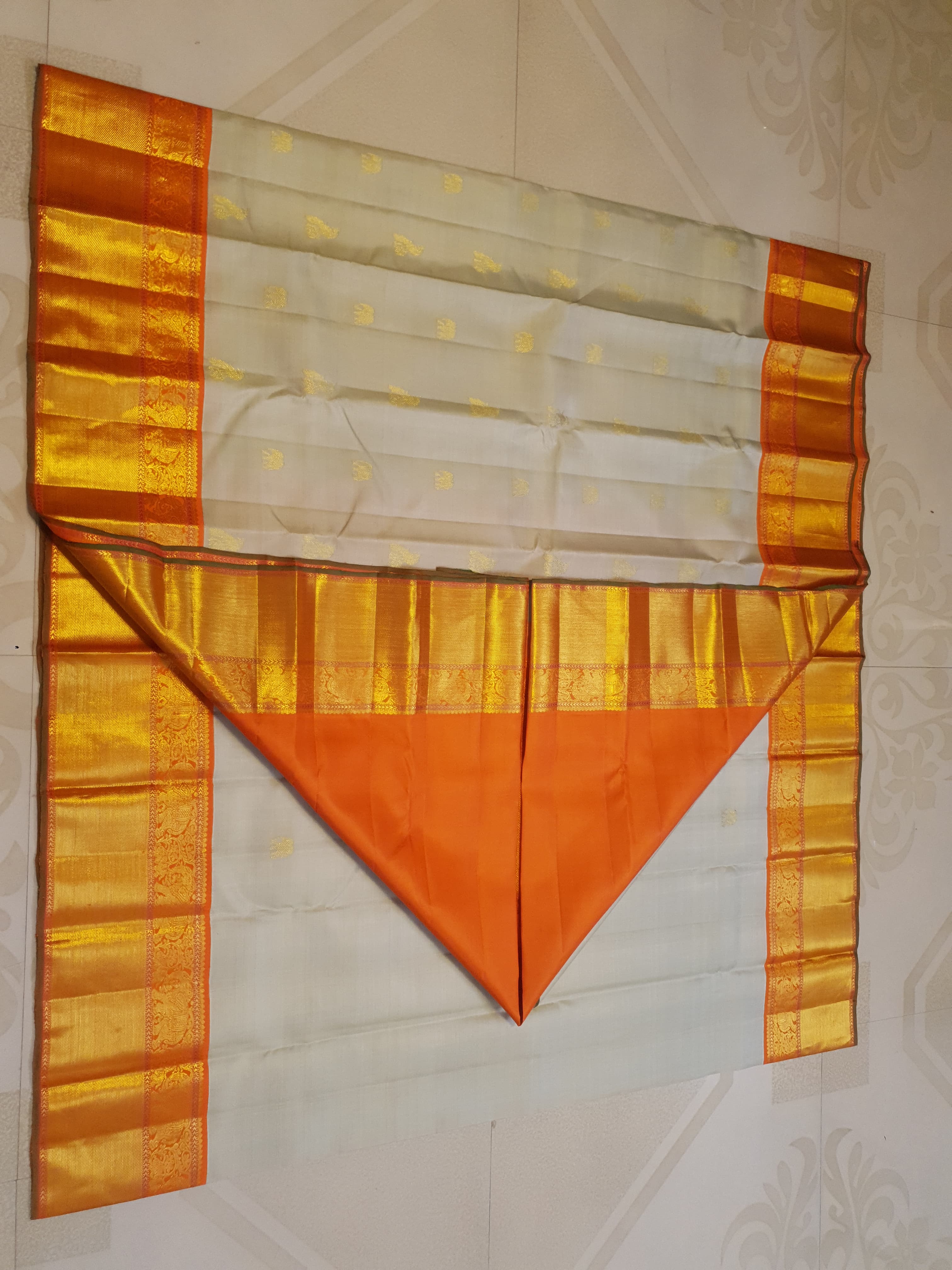 Beige Kanchipuram handloom 2G gold korvai silk saree with a striking orange and gold zari border.