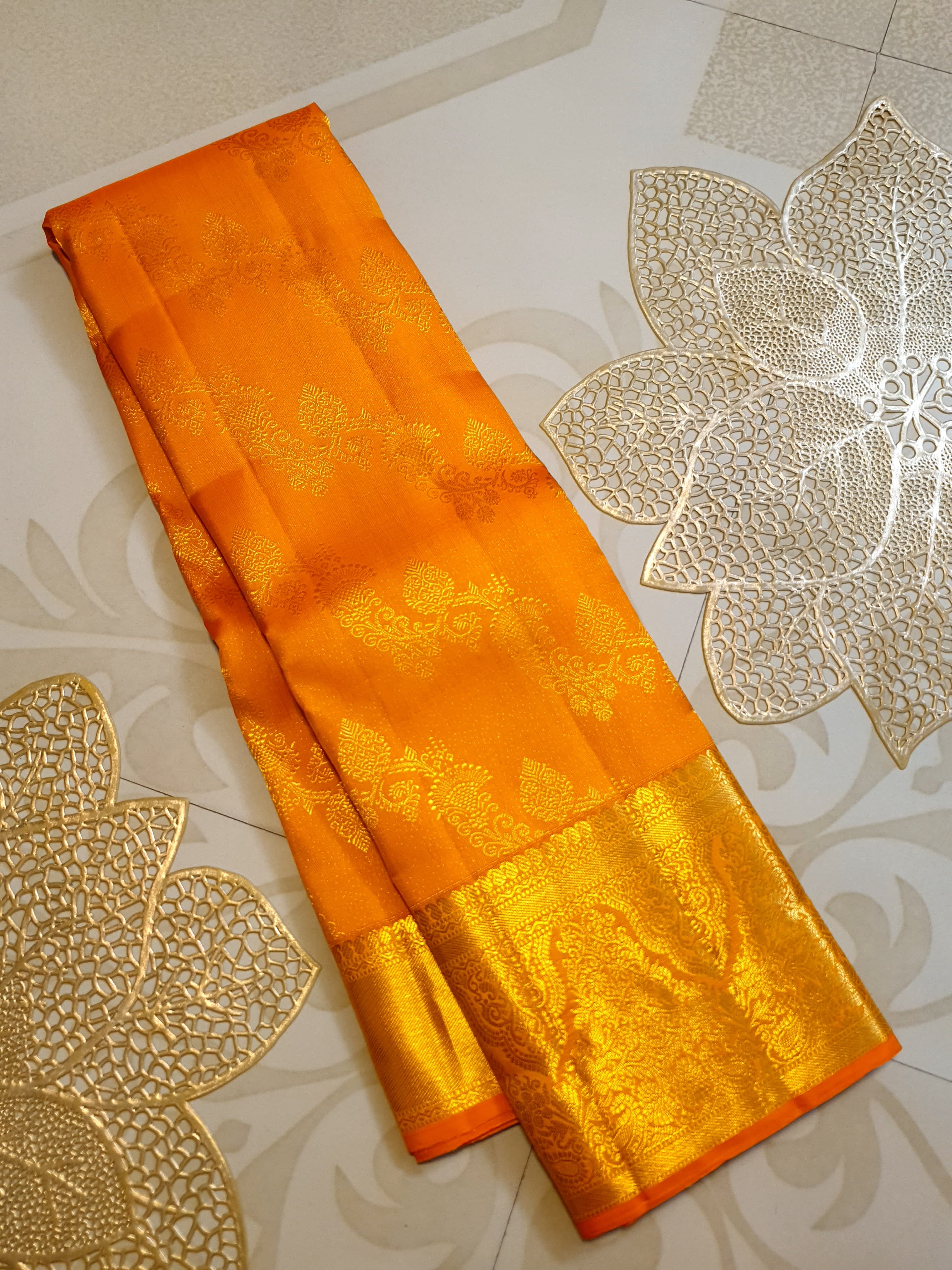 Exquisite Orange Kanchipuram handloom silk saree with intricate gold zari detailing, styled for a traditional wedding look.