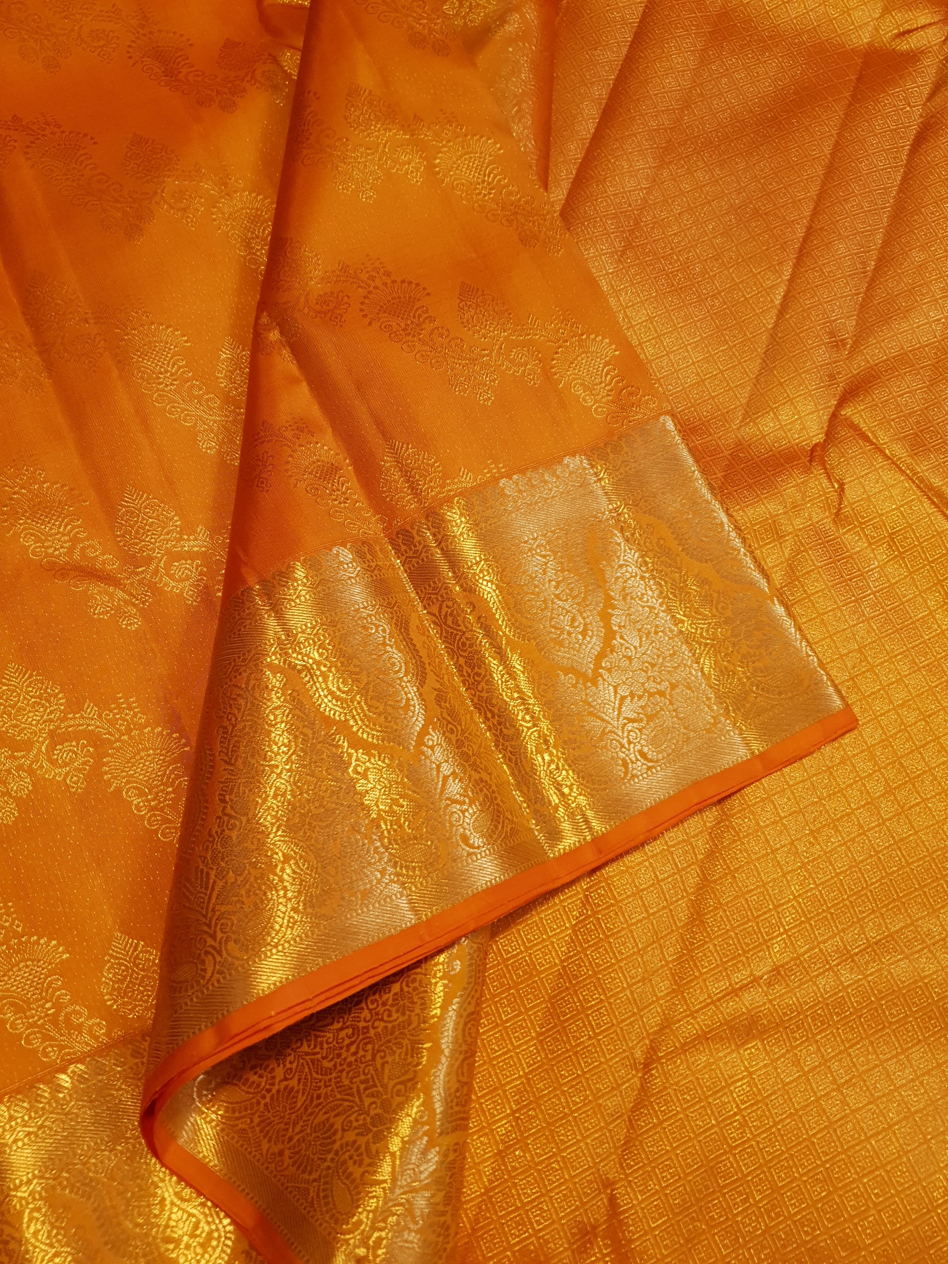 Exquisite Orange Kanchipuram handloom silk saree with intricate gold zari detailing, styled for a traditional wedding look.