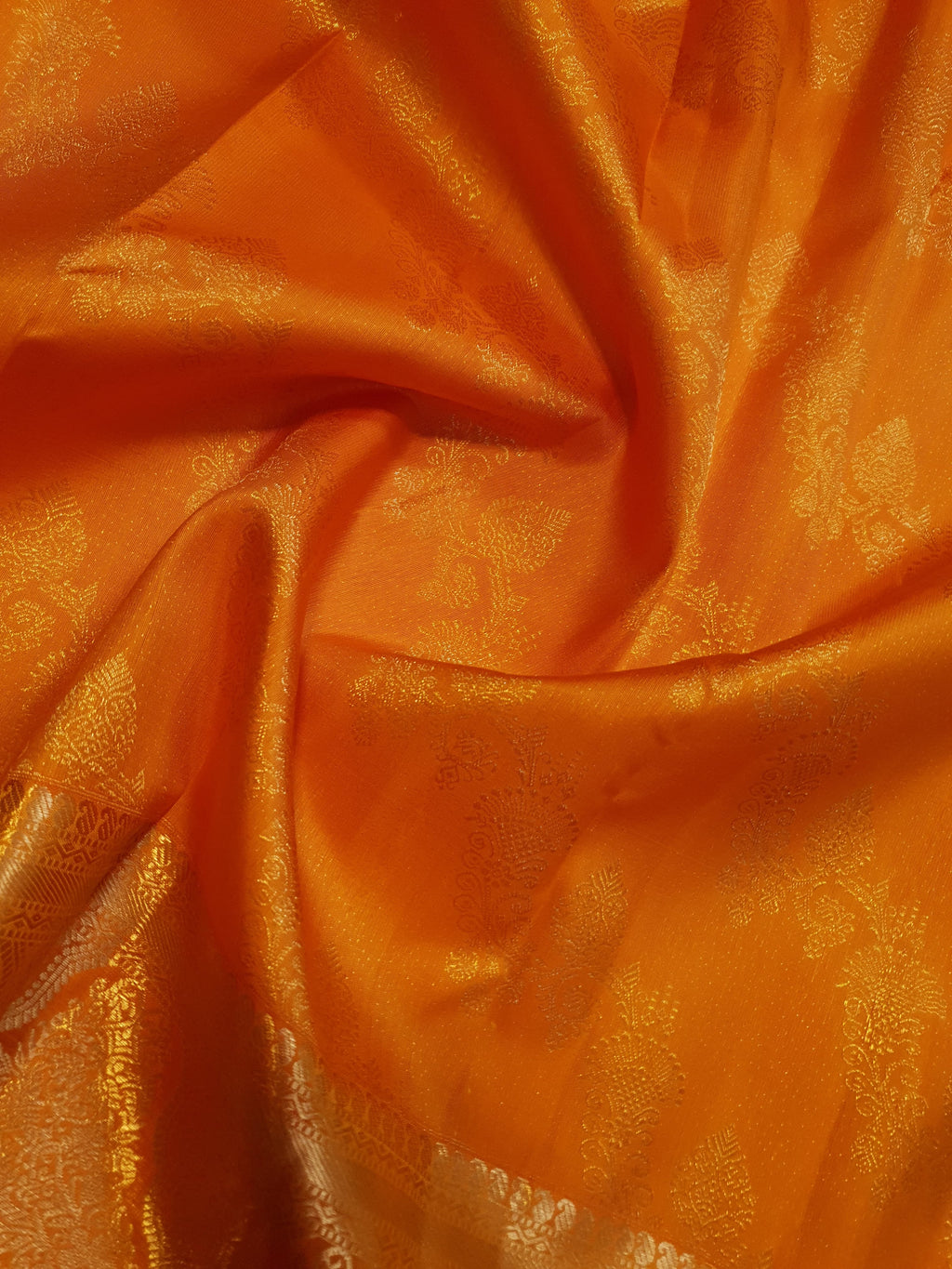 Exquisite Orange Kanchipuram handloom silk saree with intricate gold zari detailing, styled for a traditional wedding look.