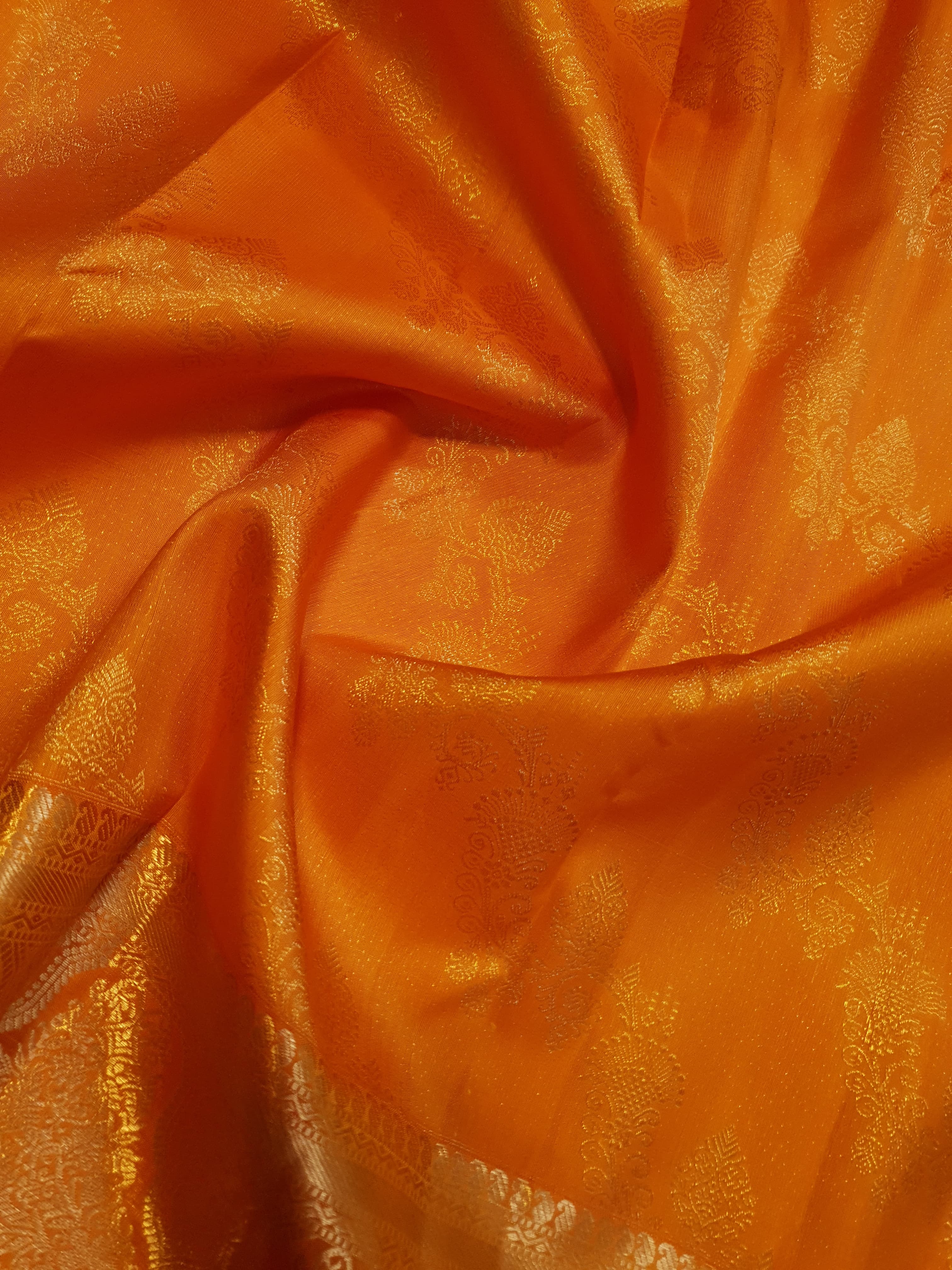 Exquisite Orange Kanchipuram handloom silk saree with intricate gold zari detailing, styled for a traditional wedding look.