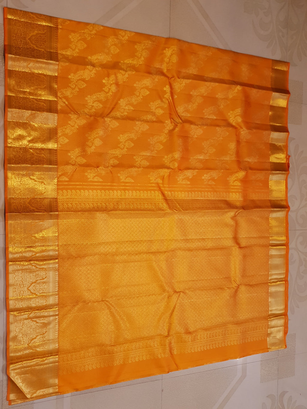 Exquisite Orange Kanchipuram handloom silk saree with intricate gold zari detailing, styled for a traditional wedding look.