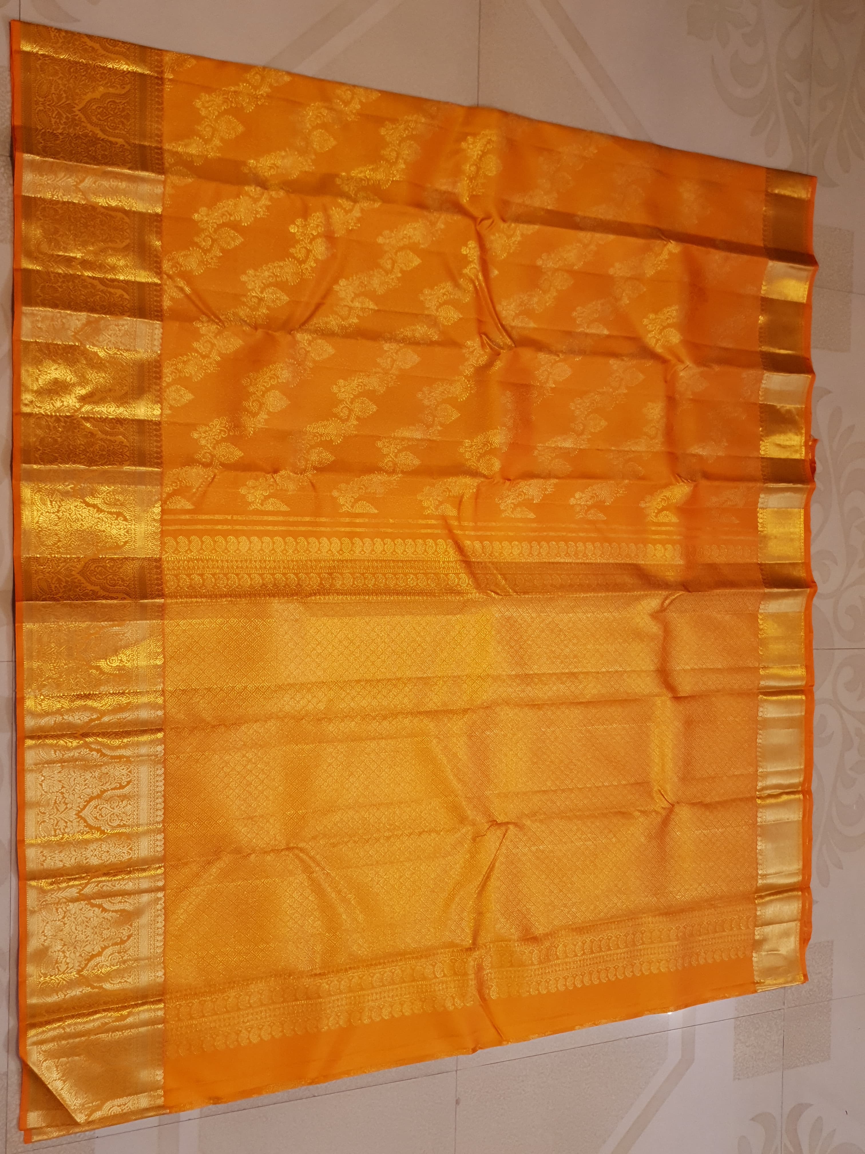 Exquisite Orange Kanchipuram handloom silk saree with intricate gold zari detailing, styled for a traditional wedding look.