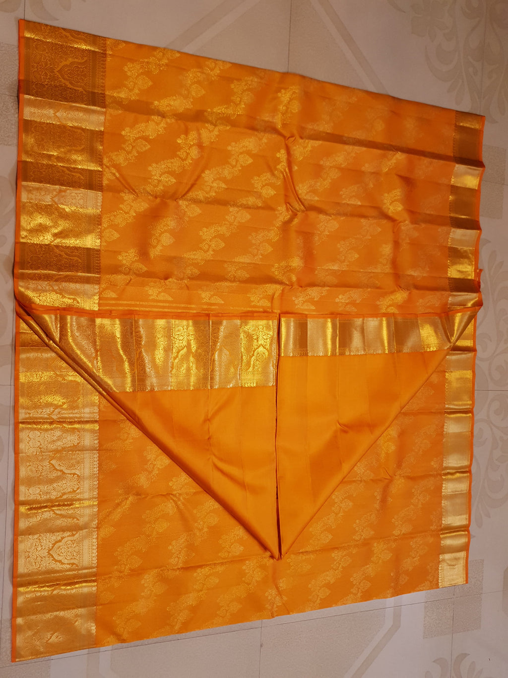 Exquisite Orange Kanchipuram handloom silk saree with intricate gold zari detailing, styled for a traditional wedding look.
