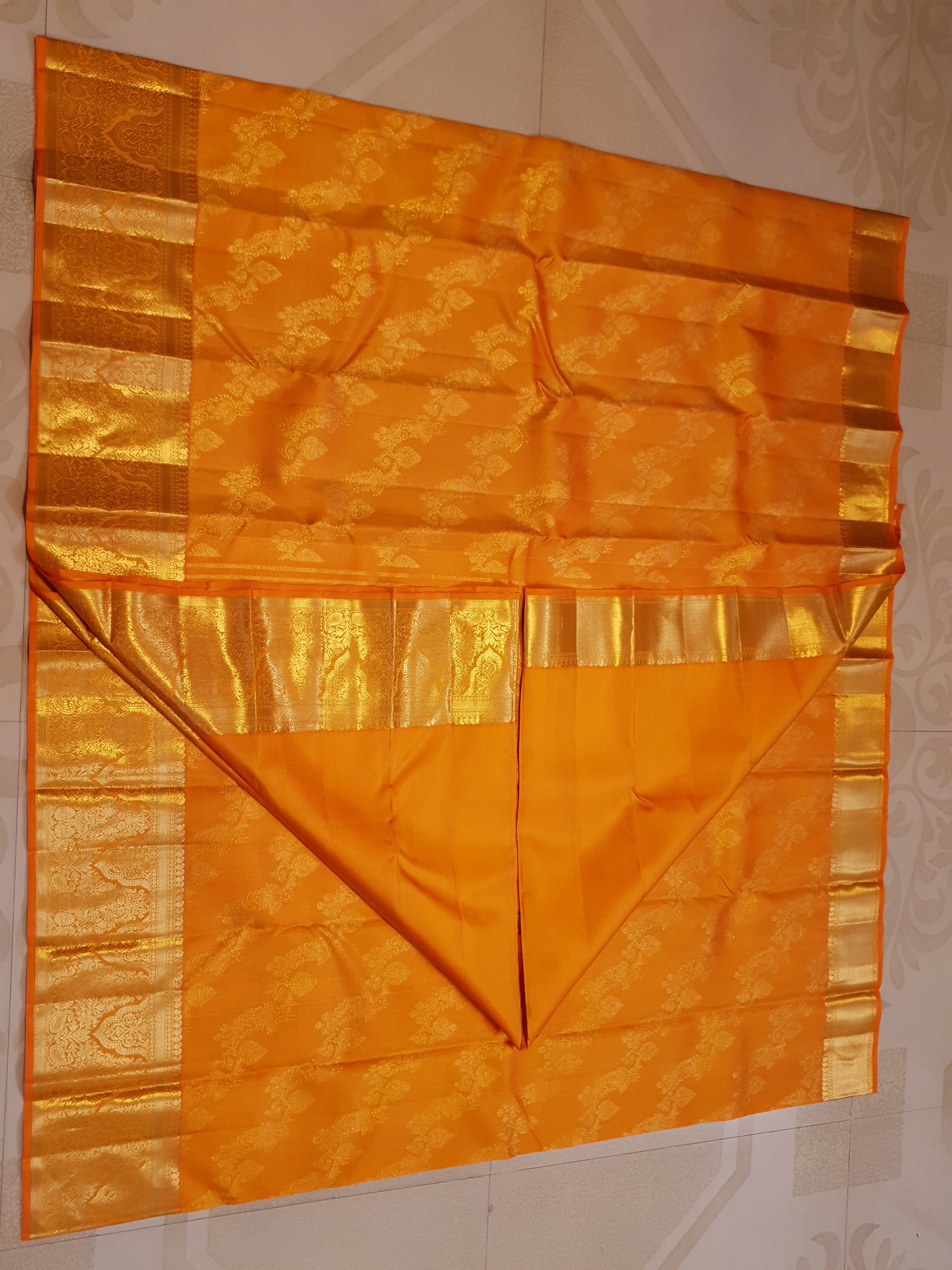 Exquisite Orange Kanchipuram handloom silk saree with intricate gold zari detailing, styled for a traditional wedding look.