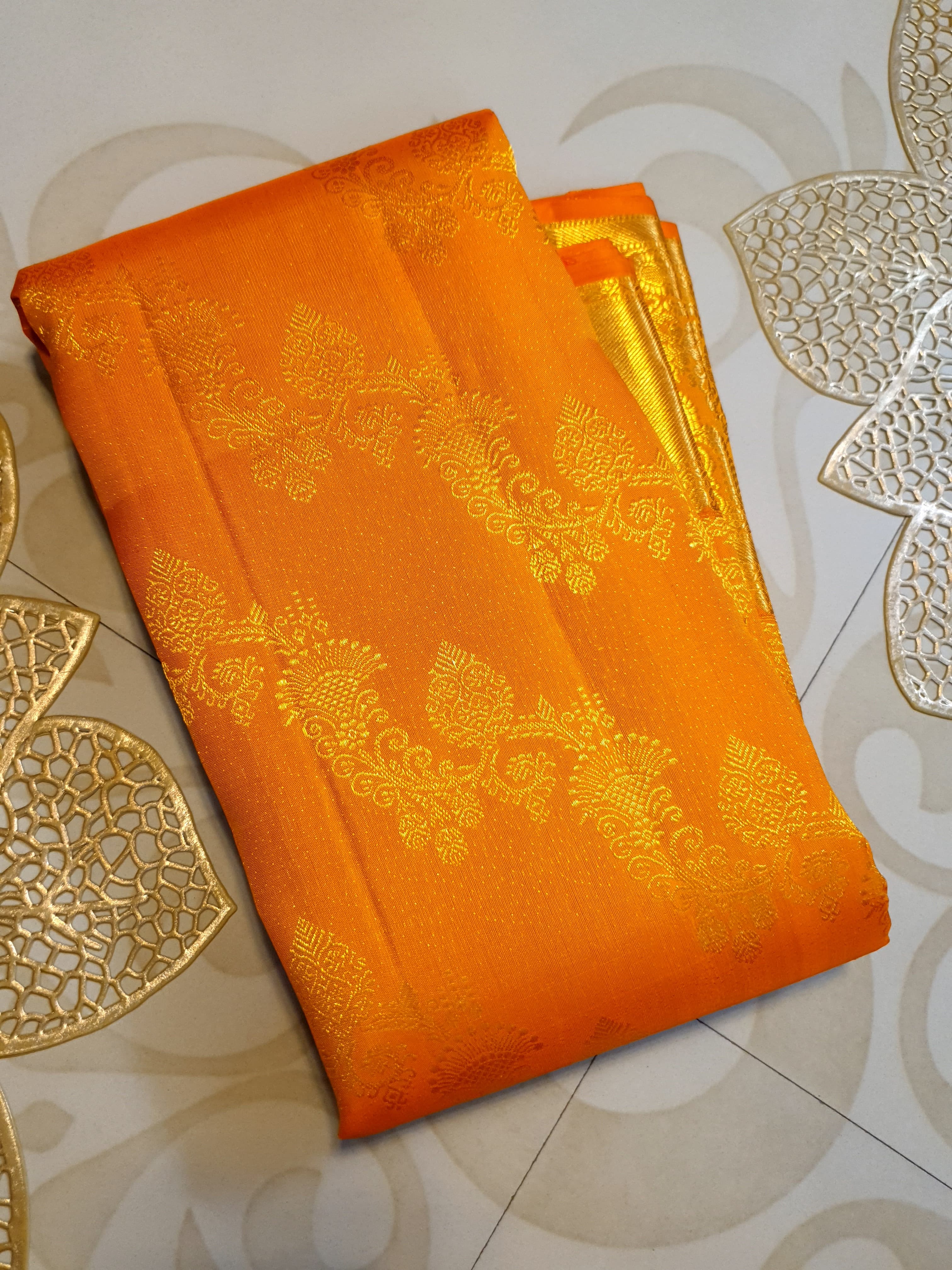 Exquisite Orange Kanchipuram handloom silk saree with intricate gold zari detailing, styled for a traditional wedding look.