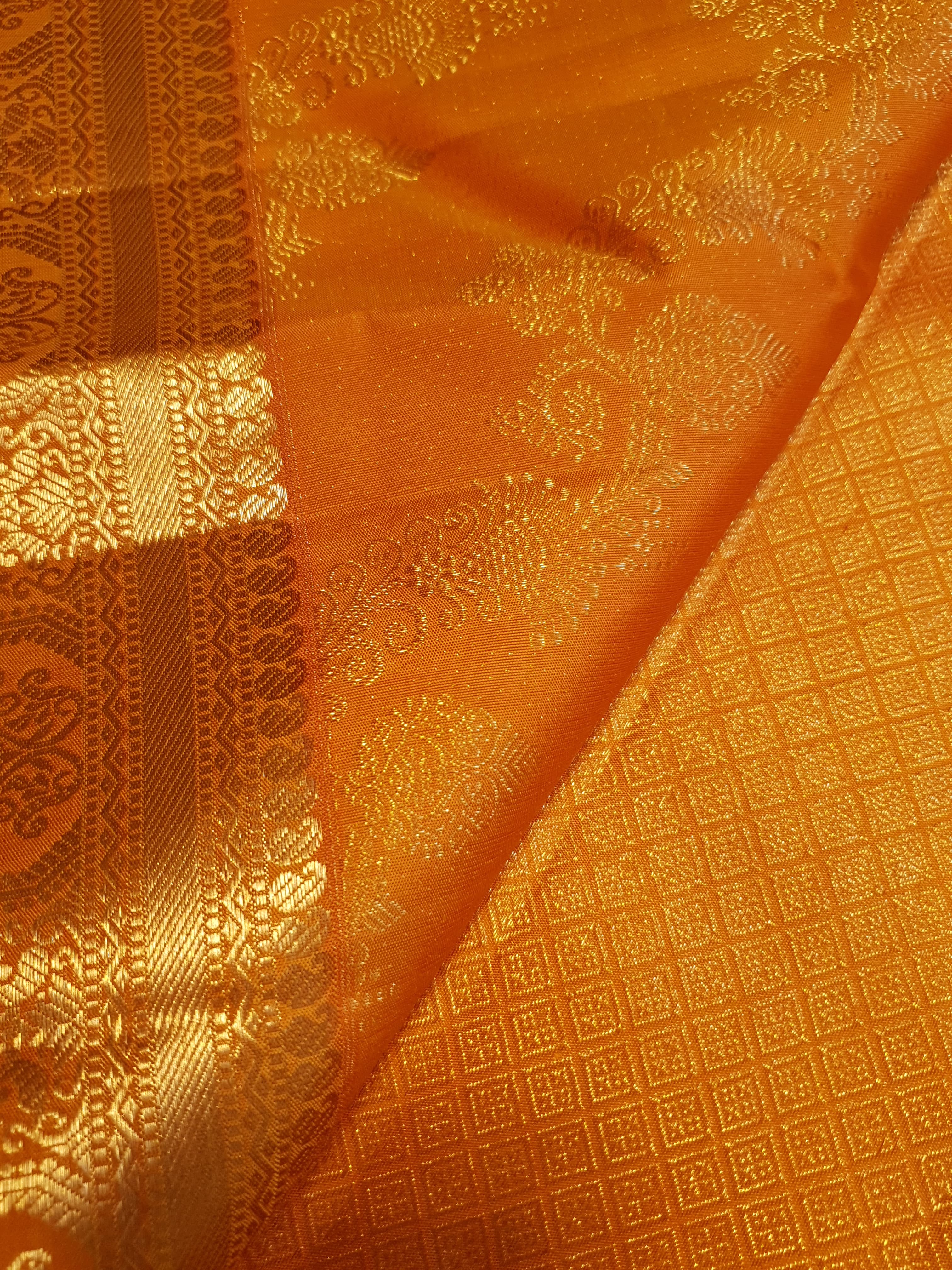 Exquisite Orange Kanchipuram handloom silk saree with intricate gold zari detailing, styled for a traditional wedding look.