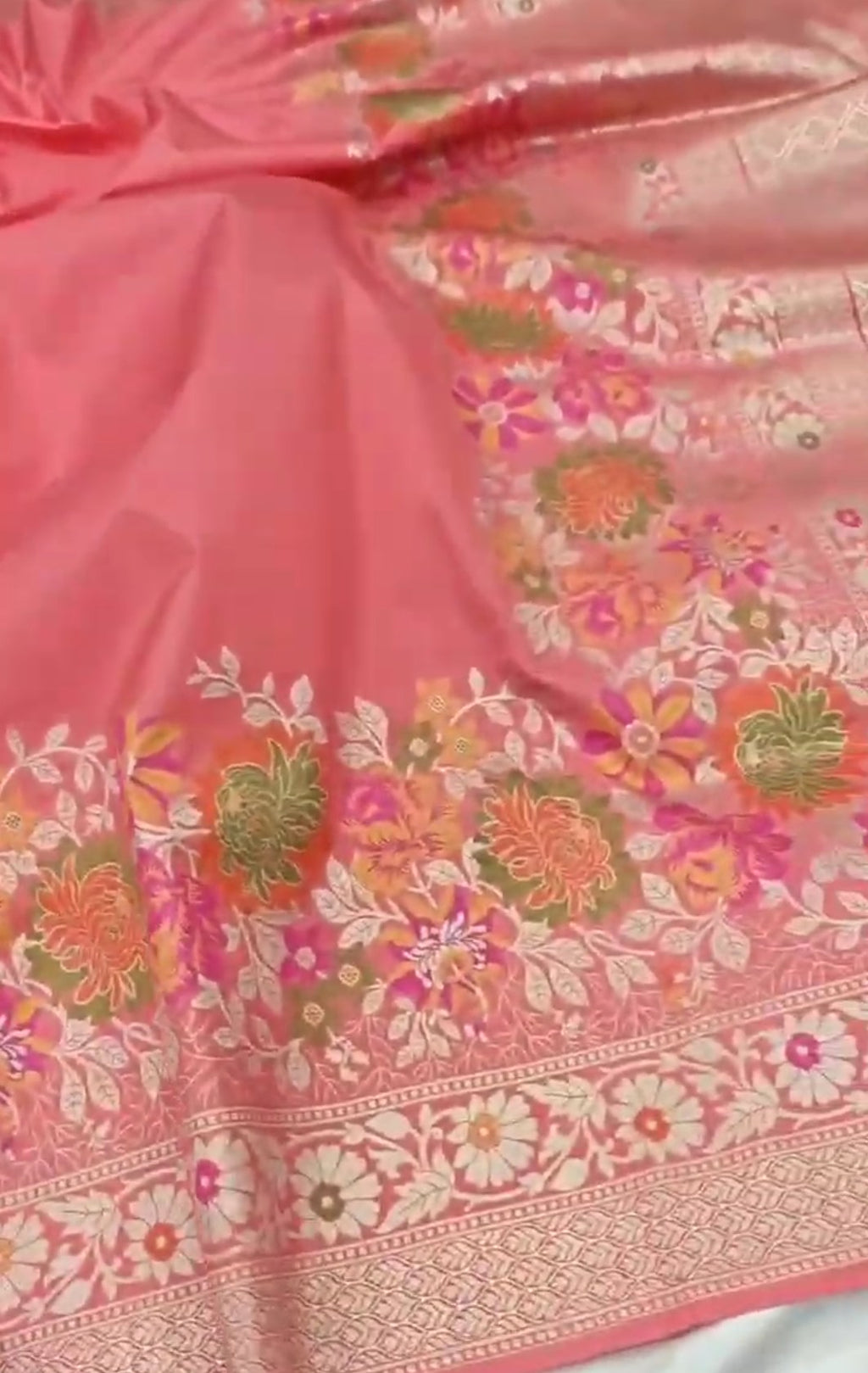 A soft peach Banarasi semi Katan silk saree with a plain body, featuring a multi-colored Tilfi Meenakari floral border and a matching full brocade blouse piece.