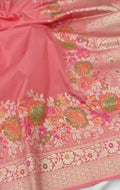 A soft peach Banarasi semi Katan silk saree with a plain body, featuring a multi-colored Tilfi Meenakari floral border and a matching full brocade blouse piece.
