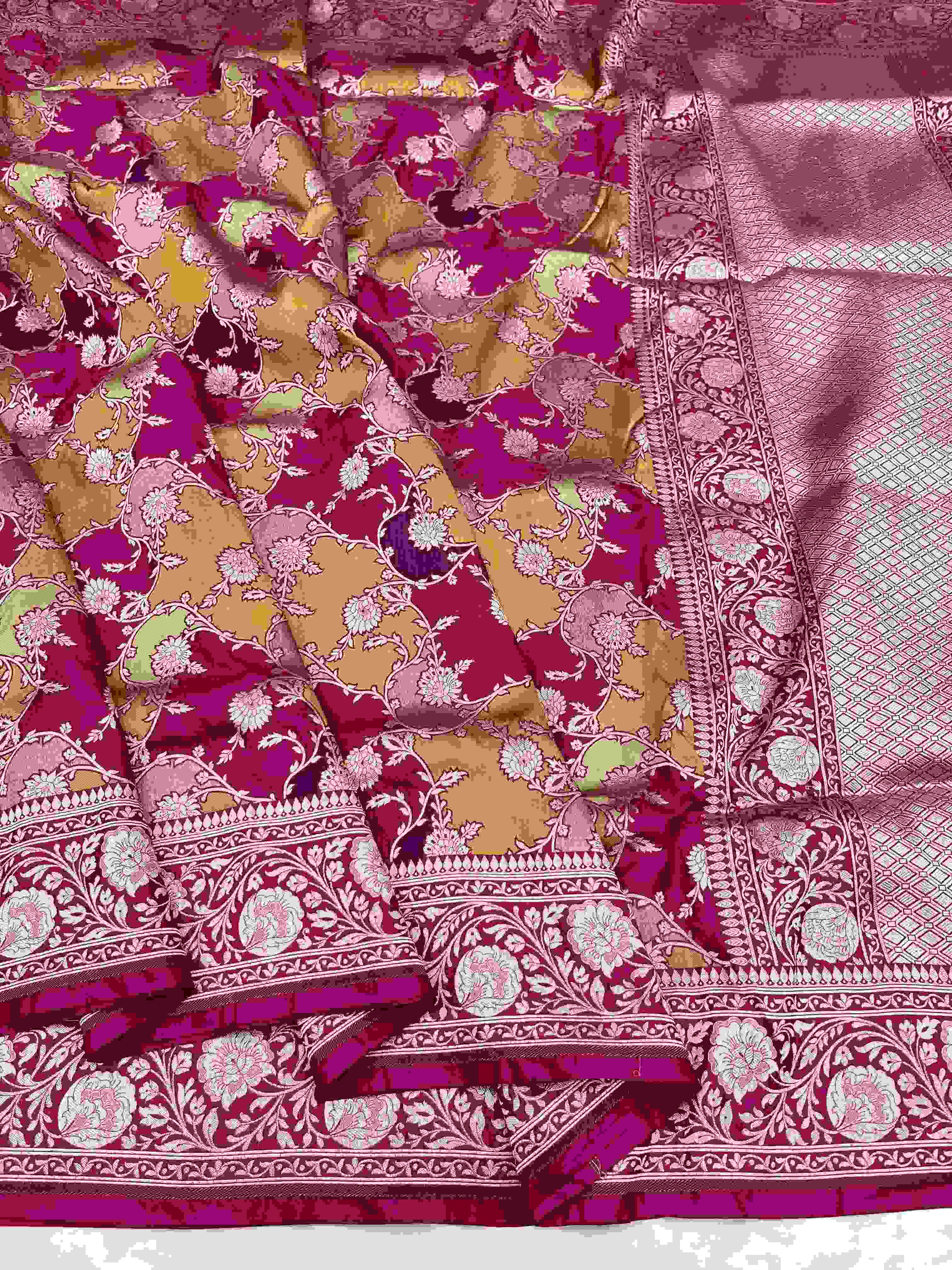 A vibrant hot pink Banarasi Katan silk saree featuring hand-woven Rangkaat diagonal color blocks and intricate Meenakari floral vines in shimmering gold zari.