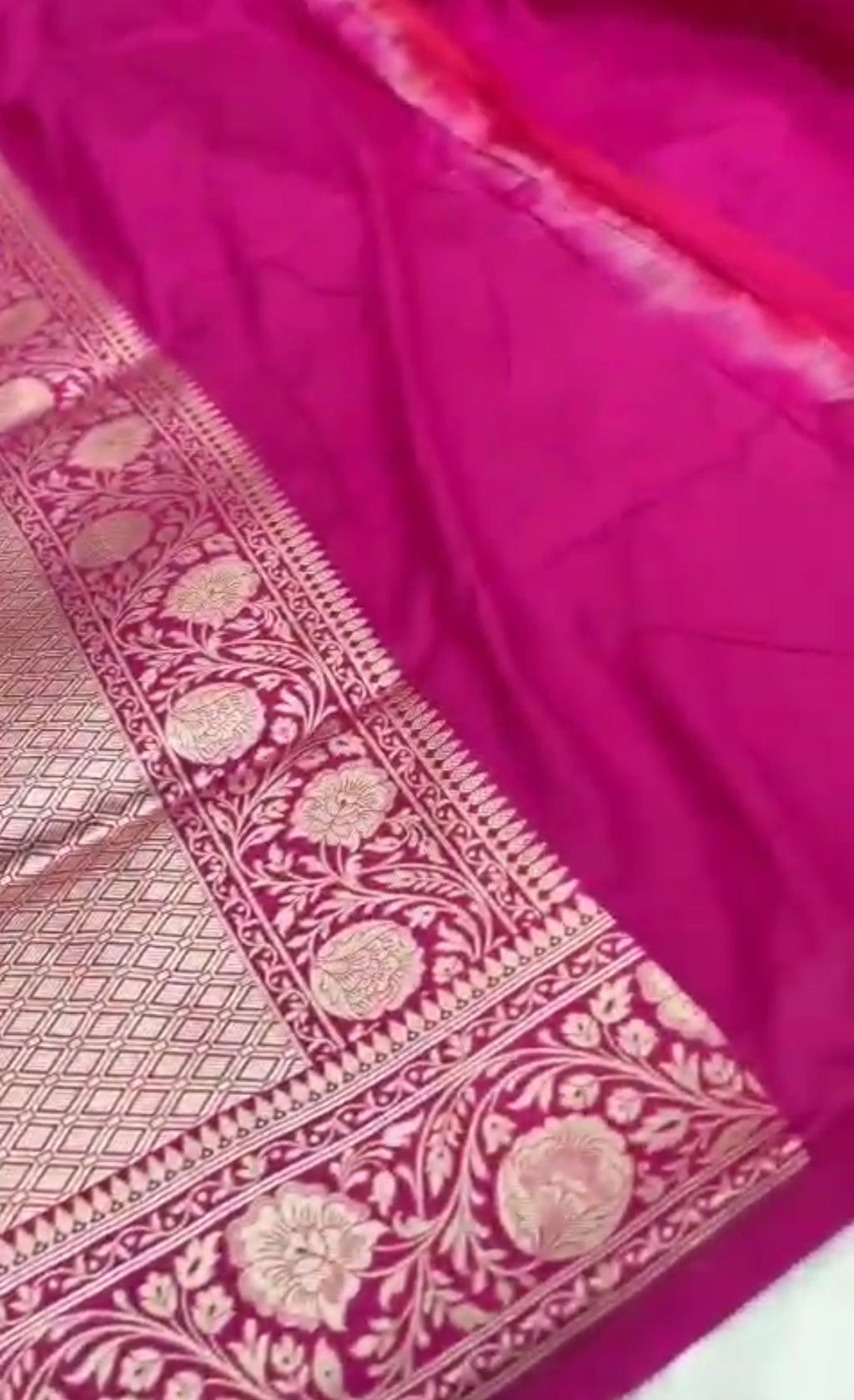 A vibrant hot pink Banarasi Katan silk saree featuring hand-woven Rangkaat diagonal color blocks and intricate Meenakari floral vines in shimmering gold zari.