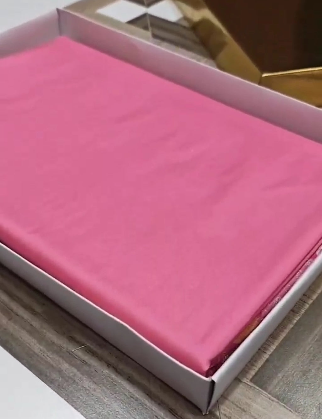 A soft pastel pink Banarasi saree with a plain silk body, a heavy Tilfi Meenakari floral border, and a matching full brocade blouse piece.