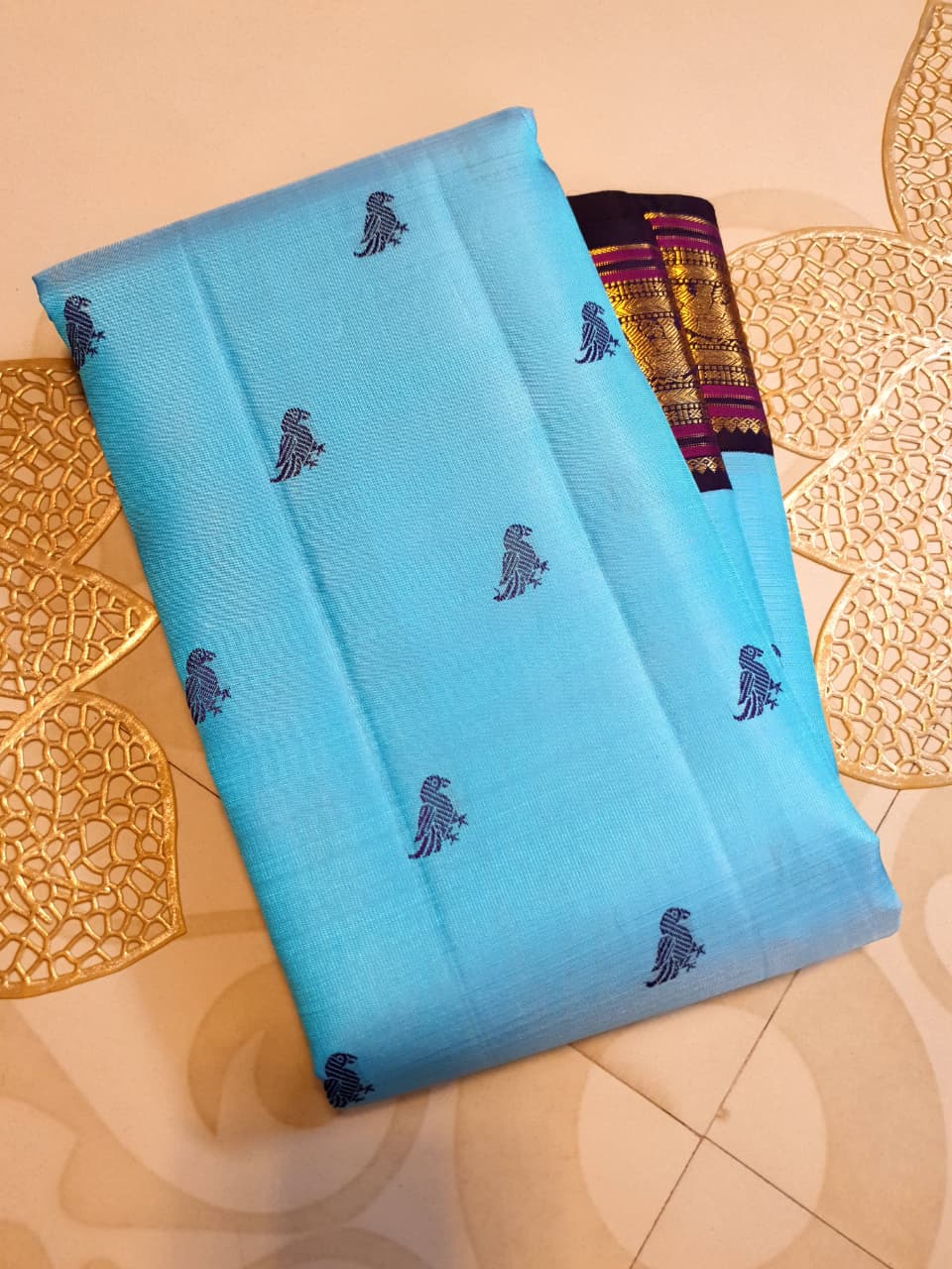 A elegant drape of a turquoise Kanchipuram Korvai silk saree showcasing the intricate interlocking border design and 3G gold zari details.