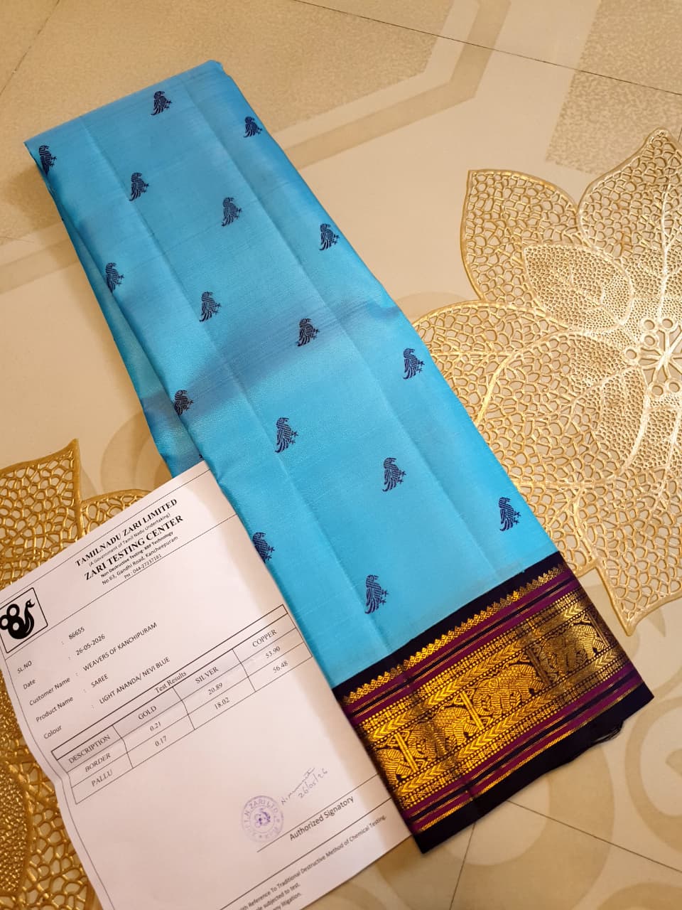 A elegant drape of a turquoise Kanchipuram Korvai silk saree showcasing the intricate interlocking border design and 3G gold zari details.