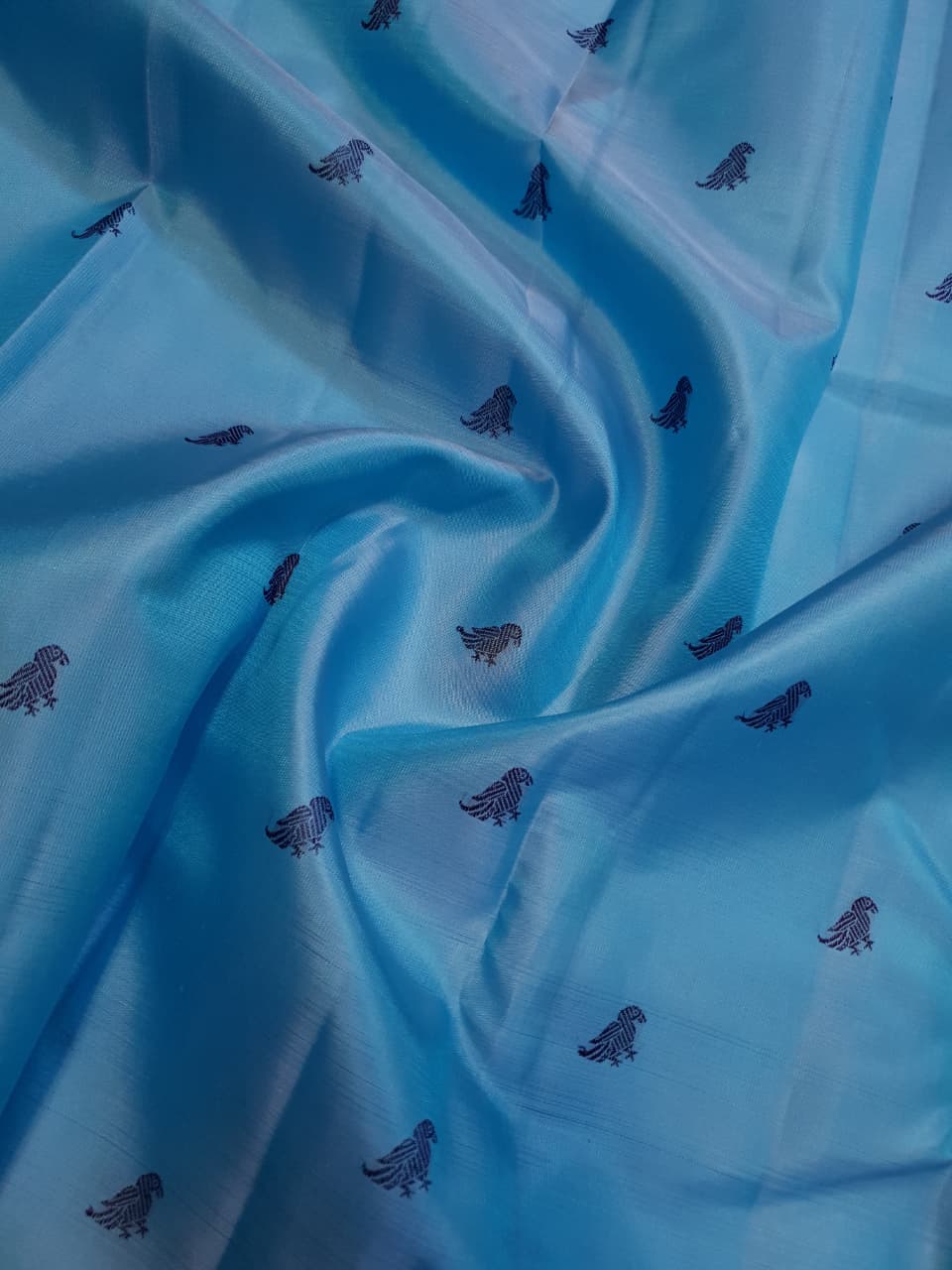 A elegant drape of a turquoise Kanchipuram Korvai silk saree showcasing the intricate interlocking border design and 3G gold zari details.