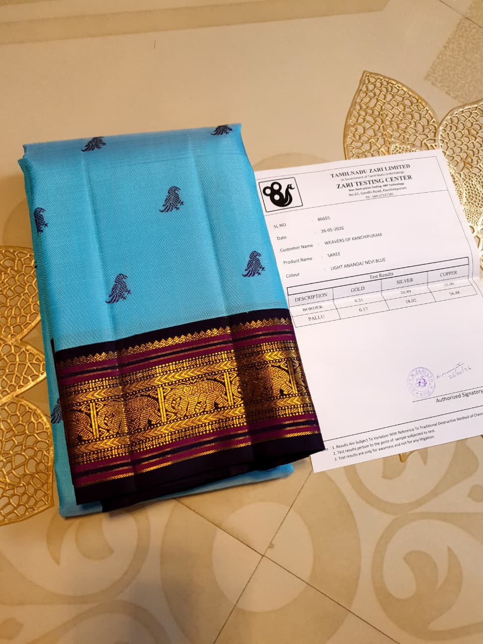 A elegant drape of a turquoise Kanchipuram Korvai silk saree showcasing the intricate interlocking border design and 3G gold zari details.