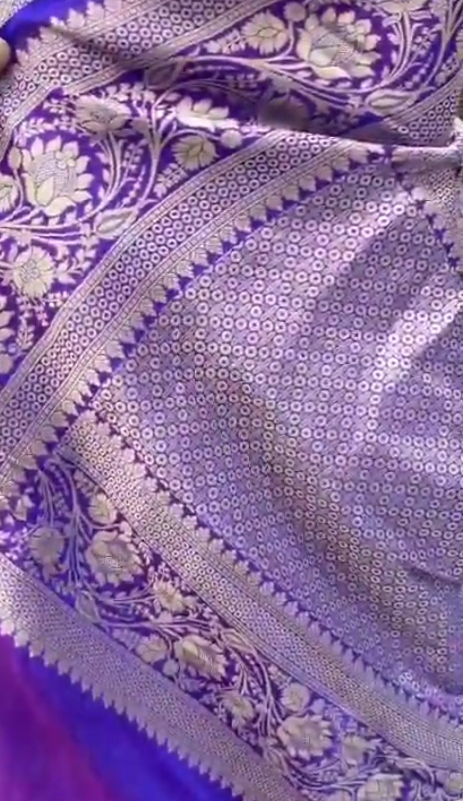 A deep purple Banarasi Katan silk saree featuring vibrant three-colored Tilfi Meenakari floral buttas and an ornate gold zari border.