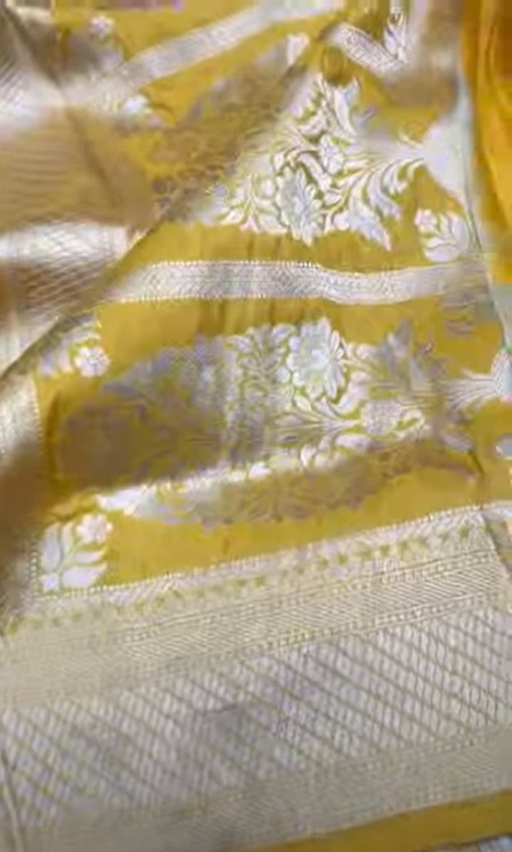 A radiant dual-tone golden yellow Banarasi Katan silk saree with hand-woven Sona Rupa gold and silver zari floral motifs and a rich border.
