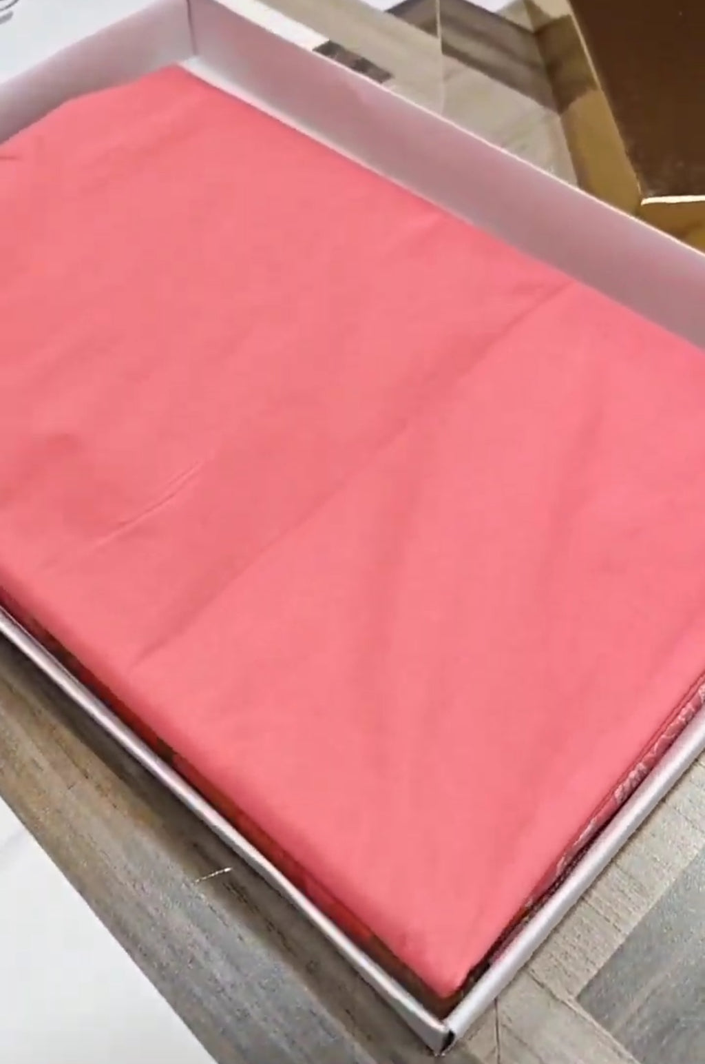 A soft peach Banarasi semi Katan silk saree with a plain body, featuring a multi-colored Tilfi Meenakari floral border and a matching full brocade blouse piece.