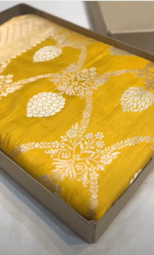 A radiant dual-tone golden yellow Banarasi Katan silk saree with hand-woven Sona Rupa gold and silver zari floral motifs and a rich border.