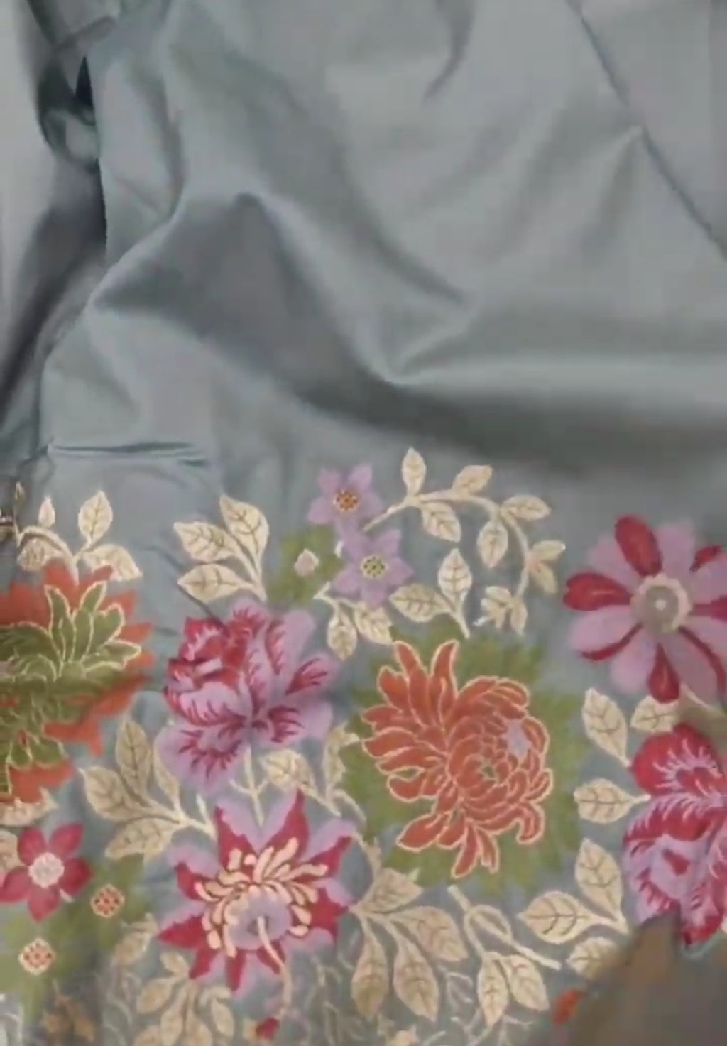 A serene powder blue Banarasi semi Katan silk saree with a plain body, a multi-colored Tilfi Meenakari floral border, and a matching heavy brocade blouse.