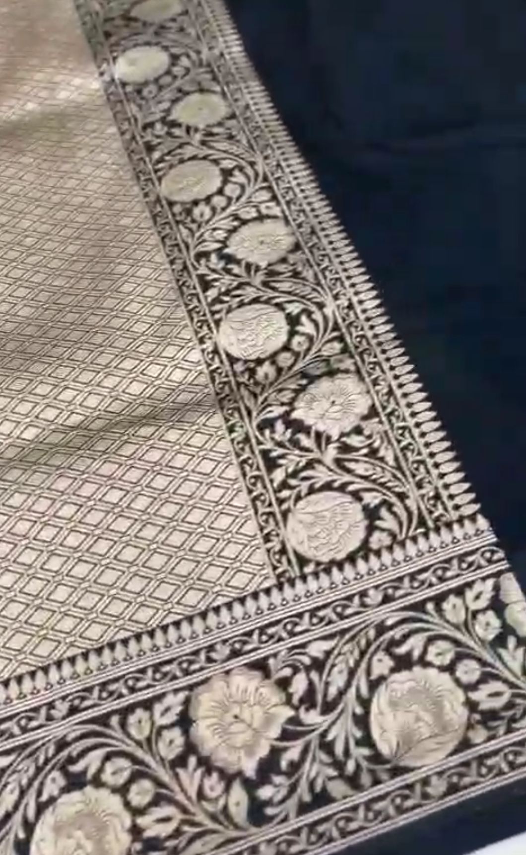A majestic black Banarasi Katan silk saree featuring hand-woven Rangkaat diagonal color blocks and intricate Meenakari floral vines in shimmering gold zari.