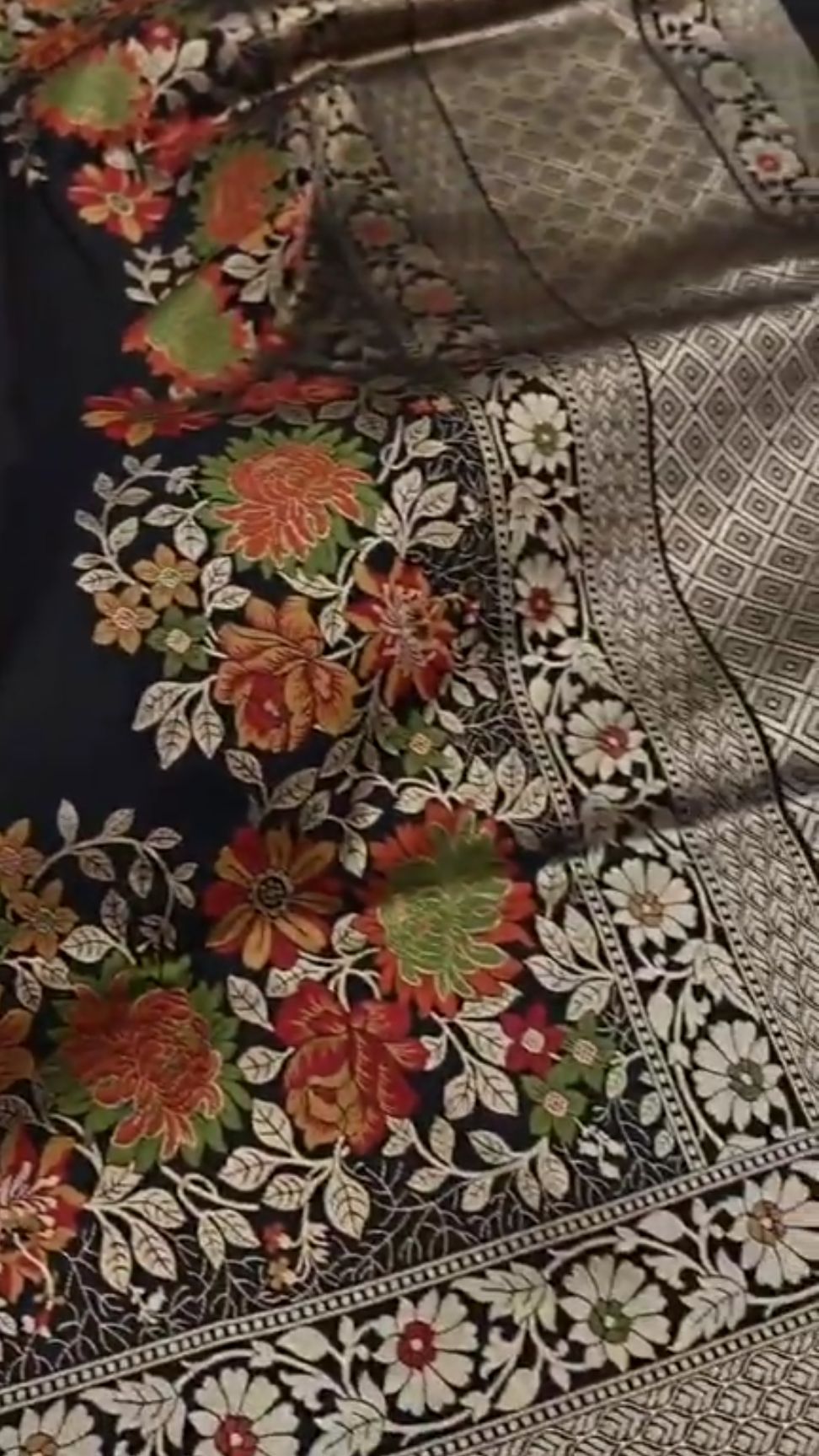 A majestic black Banarasi semi Katan silk saree with a plain body, vibrant three-colored Tilfi Meenakari floral borders, and an ornate gold zari blouse.