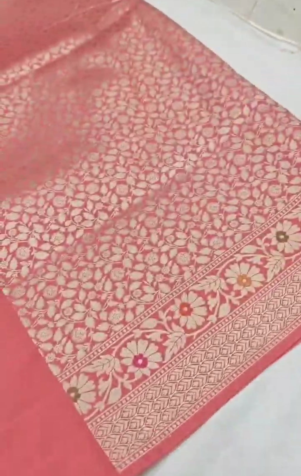 A soft peach Banarasi semi Katan silk saree with a plain body, featuring a multi-colored Tilfi Meenakari floral border and a matching full brocade blouse piece.