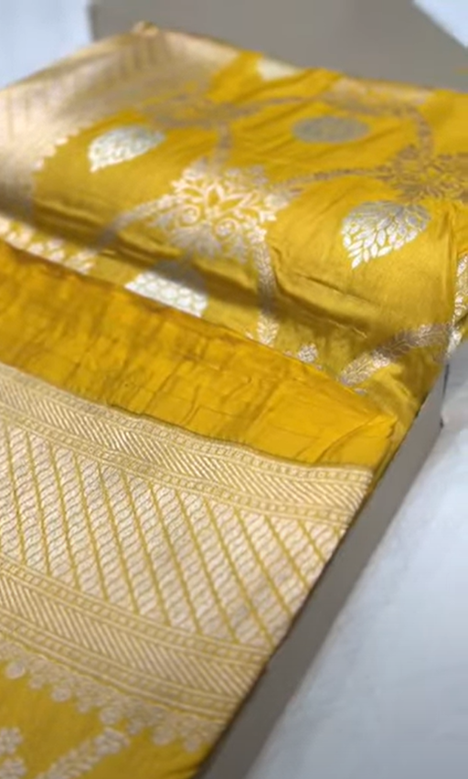 A radiant dual-tone golden yellow Banarasi Katan silk saree with hand-woven Sona Rupa gold and silver zari floral motifs and a rich border.