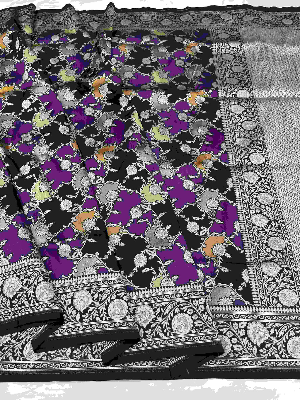 A majestic black Banarasi Katan silk saree featuring hand-woven Rangkaat diagonal color blocks and intricate Meenakari floral vines in shimmering gold zari.