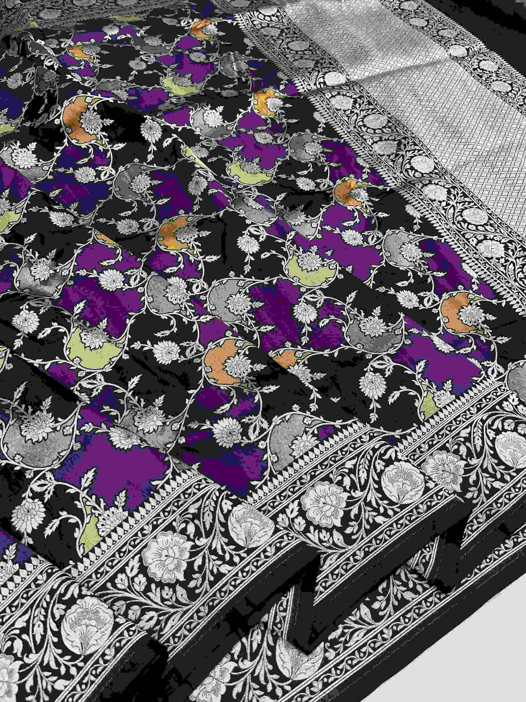 A majestic black Banarasi Katan silk saree featuring hand-woven Rangkaat diagonal color blocks and intricate Meenakari floral vines in shimmering gold zari.