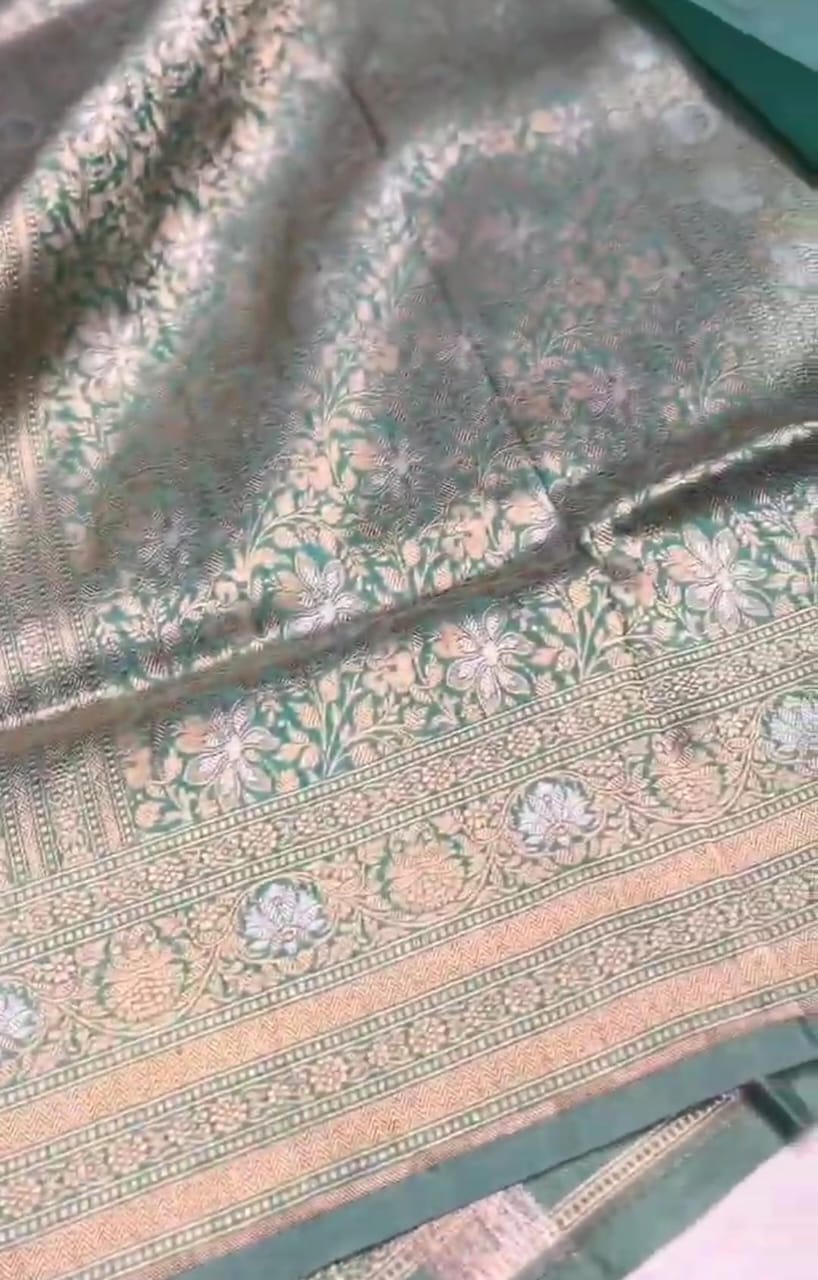 A vibrant turquoise Banarasi Katan silk saree with hand-woven Sona Rupa gold and silver zari floral motifs and an ornate border.