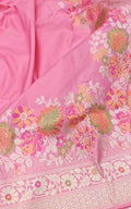 A soft pastel pink Banarasi saree with a plain silk body, a heavy Tilfi Meenakari floral border, and a matching full brocade blouse piece.