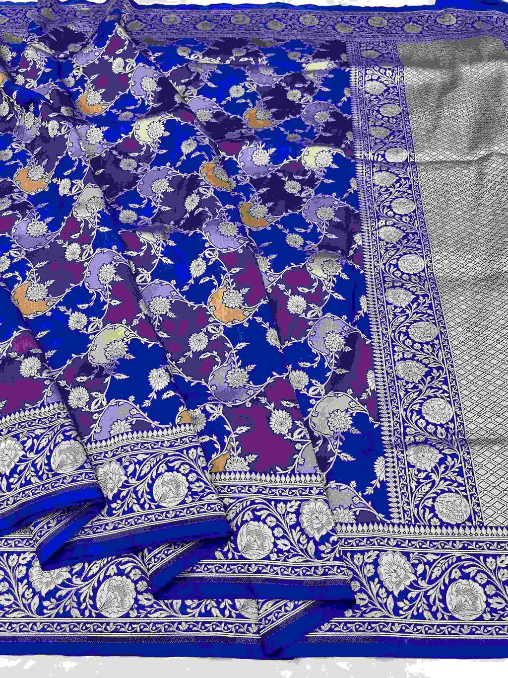 A deep azure blue Banarasi Katan silk saree featuring hand-woven Rangkaat diagonal color blocks and intricate Meenakari floral vines in gold zari.