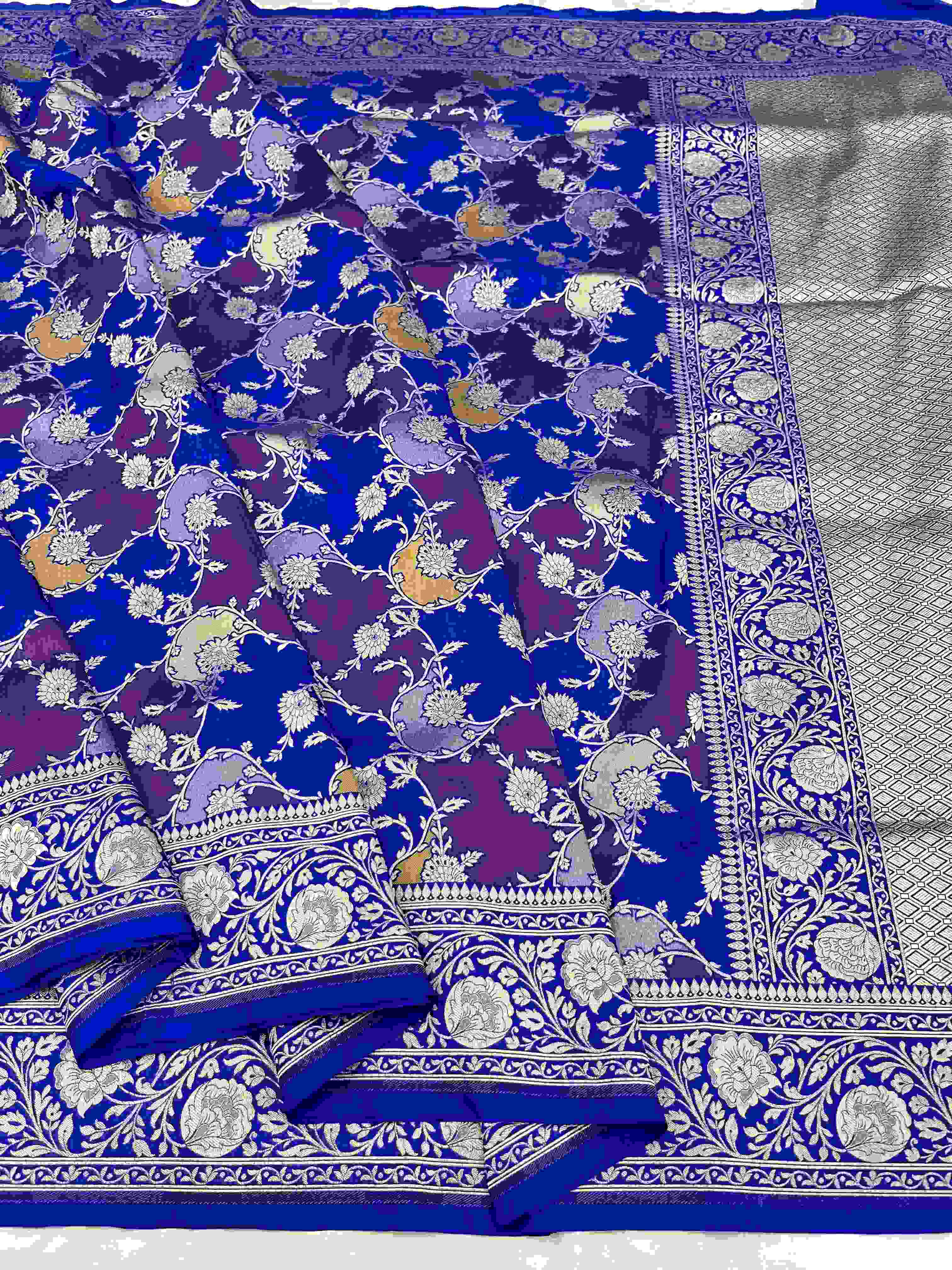 A deep azure blue Banarasi Katan silk saree featuring hand-woven Rangkaat diagonal color blocks and intricate Meenakari floral vines in gold zari.
