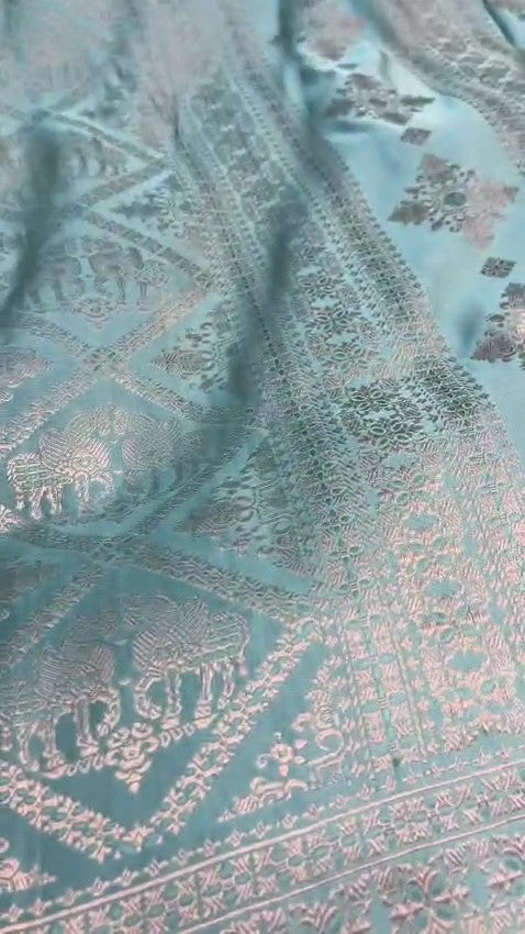 Shop our premium Dual Tone Turquoise Banarasi Handloom Katan Silk Saree. Silk Mark Certified for authenticity, this Shikargah masterpiece features rich silver zari weaving, perfect for weddings and heritage collections.