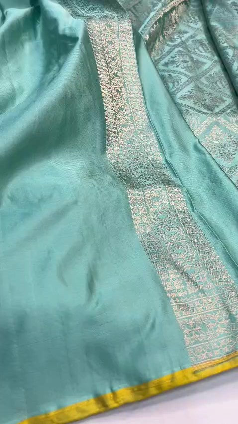 Shop our premium Dual Tone Turquoise Banarasi Handloom Katan Silk Saree. Silk Mark Certified for authenticity, this Shikargah masterpiece features rich silver zari weaving, perfect for weddings and heritage collections.
