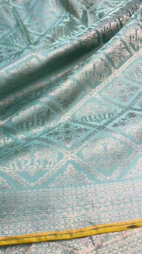 Shop our premium Dual Tone Turquoise Banarasi Handloom Katan Silk Saree. Silk Mark Certified for authenticity, this Shikargah masterpiece features rich silver zari weaving, perfect for weddings and heritage collections.