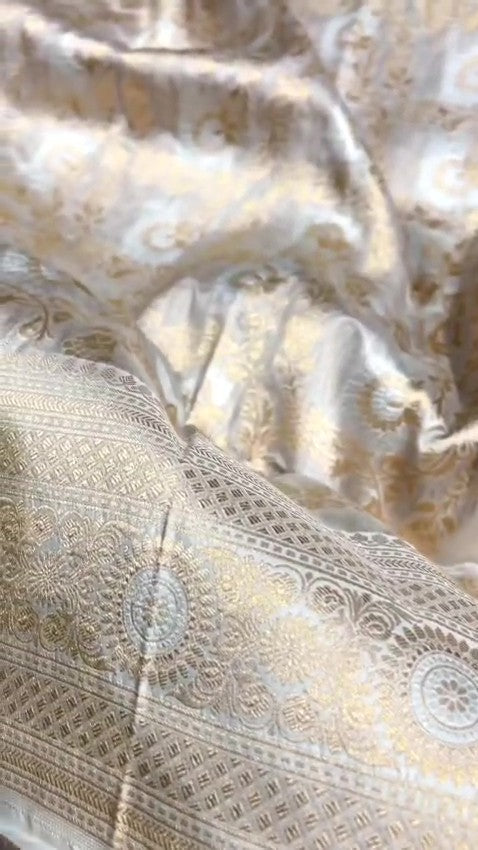 Ivory Banarasi Handloom Katan Silk Sona Rupa Saree with intricate gold zari and silver work in a traditional setting.