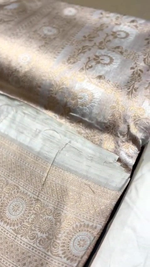 Ivory Banarasi Handloom Katan Silk Sona Rupa Saree with intricate gold zari and silver work in a traditional setting.
