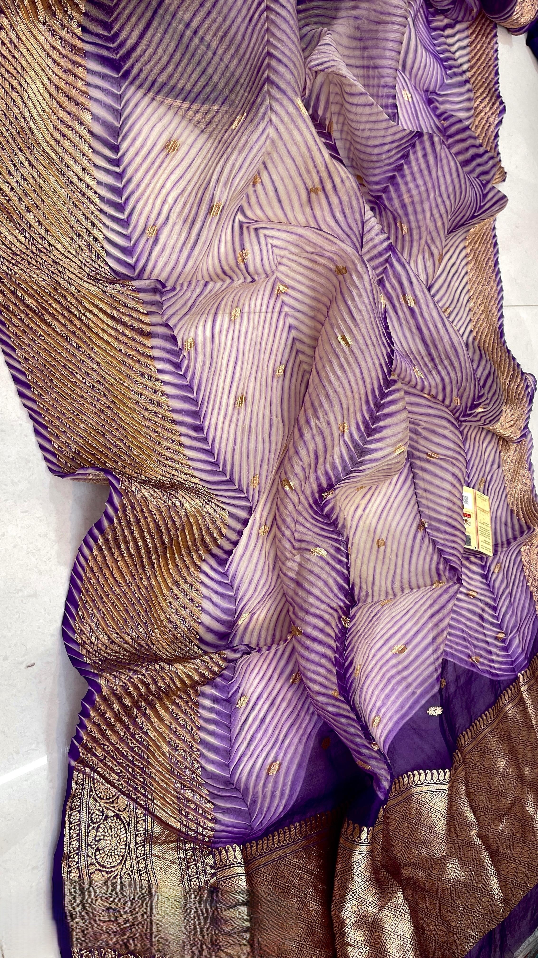A model wearing a unique lavender and purple hand-dyed diagonal Arasi Shibori Kora Tissue silk saree with elaborate gold zari borders and pallu.