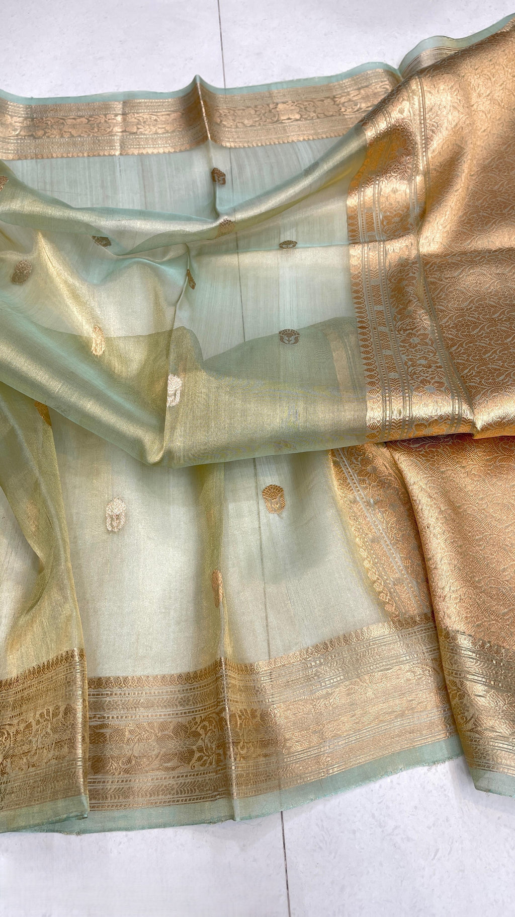 Pista Green Banarasi handloom kora tissue silk saree featuring shimmering antique zari weaving, delicate body buttas, and a certified authentic finish.