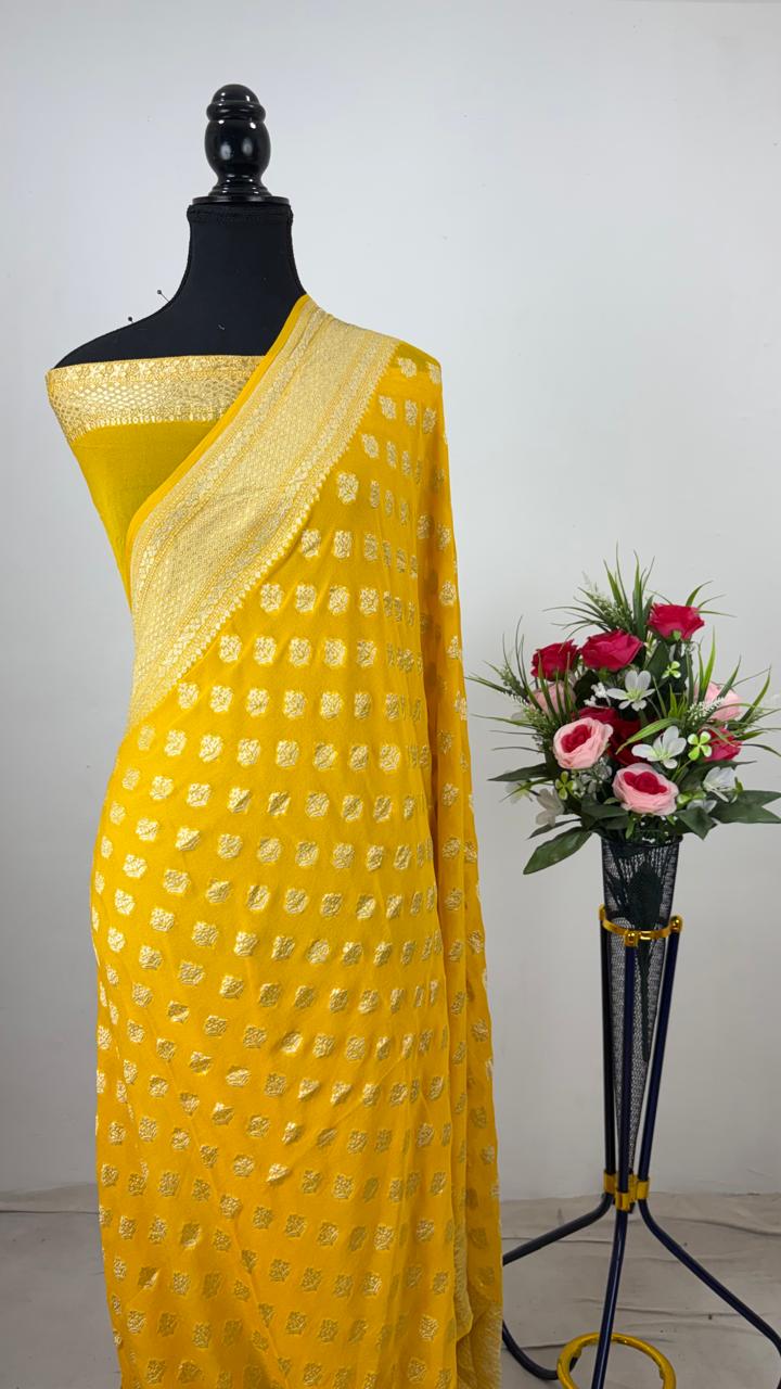 Vibrant Yellow Banarasi handloom pure georgette silk saree with intricate antique silver zari weaving against a traditional artisan background.