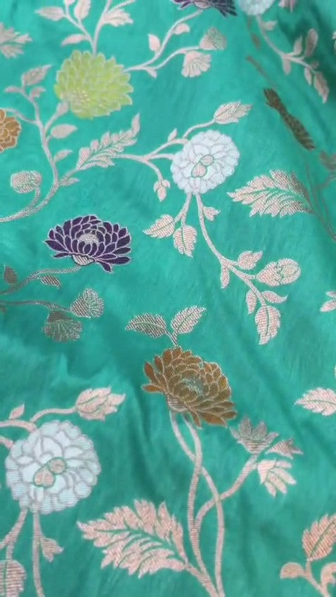 Elegant Teal Banarasi Handloom Katan silk saree with intricate multi-colored Meenakari floral motifs and detailed gold zari borders.
