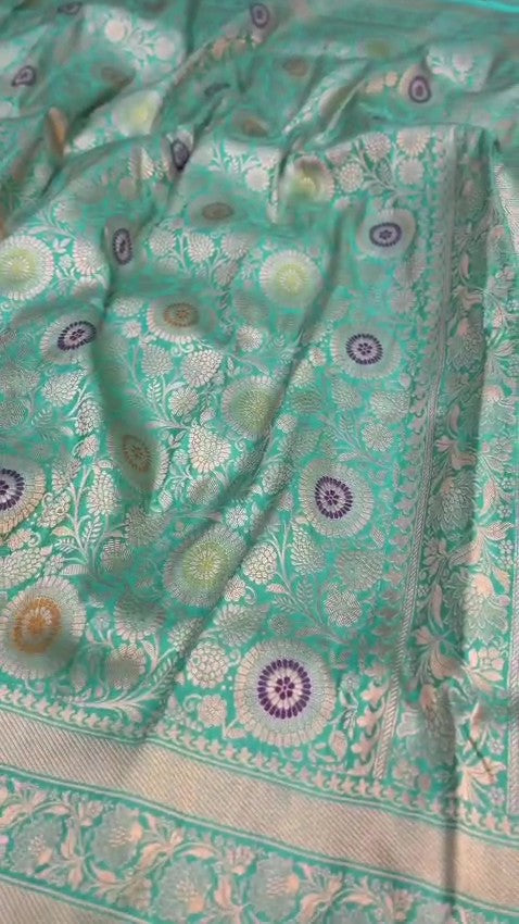 Turquoise Banarasi Handloom Katan Silk Saree with intricate multicolored chakram motifs and ornate zari borders.
