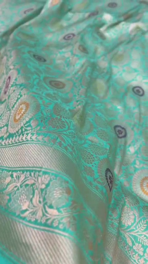 Turquoise Banarasi Handloom Katan Silk Saree with intricate multicolored chakram motifs and ornate zari borders.