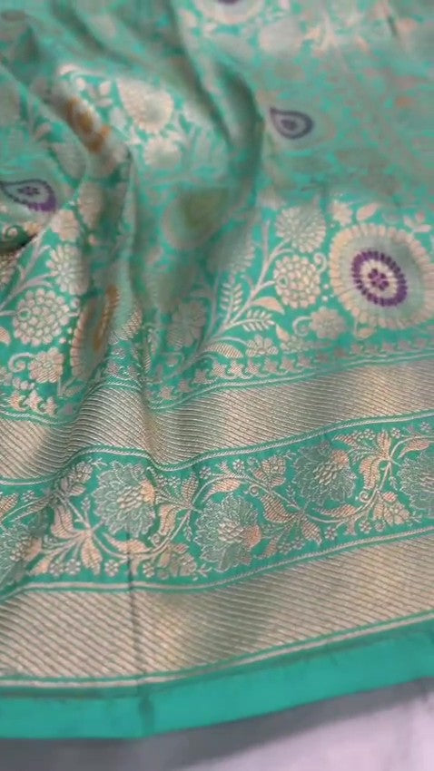 Turquoise Banarasi Handloom Katan Silk Saree with intricate multicolored chakram motifs and ornate zari borders.