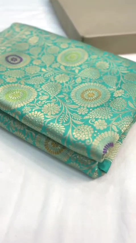 Turquoise Banarasi Handloom Katan Silk Saree with intricate multicolored chakram motifs and ornate zari borders.