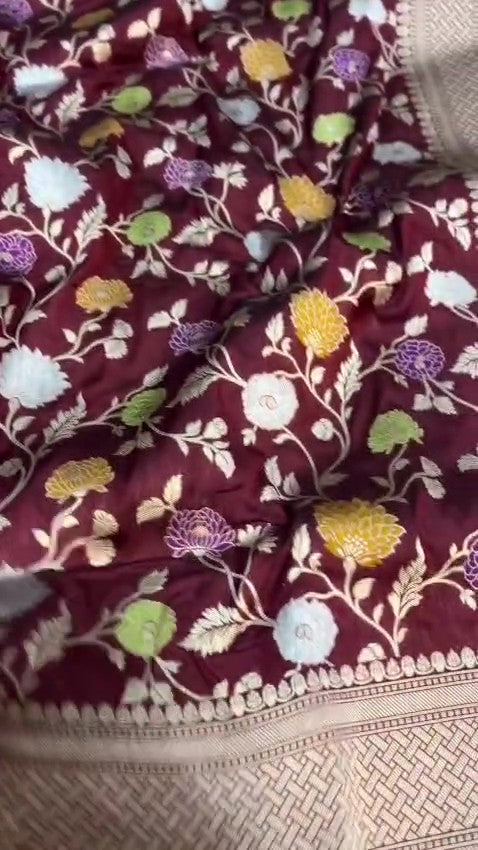 Burgundy Banarasi Handloom Katan Silk saree with elaborate multi-colored Meenakari floral motifs and grand gold zari borders.