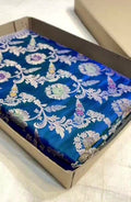Peacock blue Banarasi handloom pure katan silk saree featuring intricate silver zari weaving and colorful Meenakari floral motifs